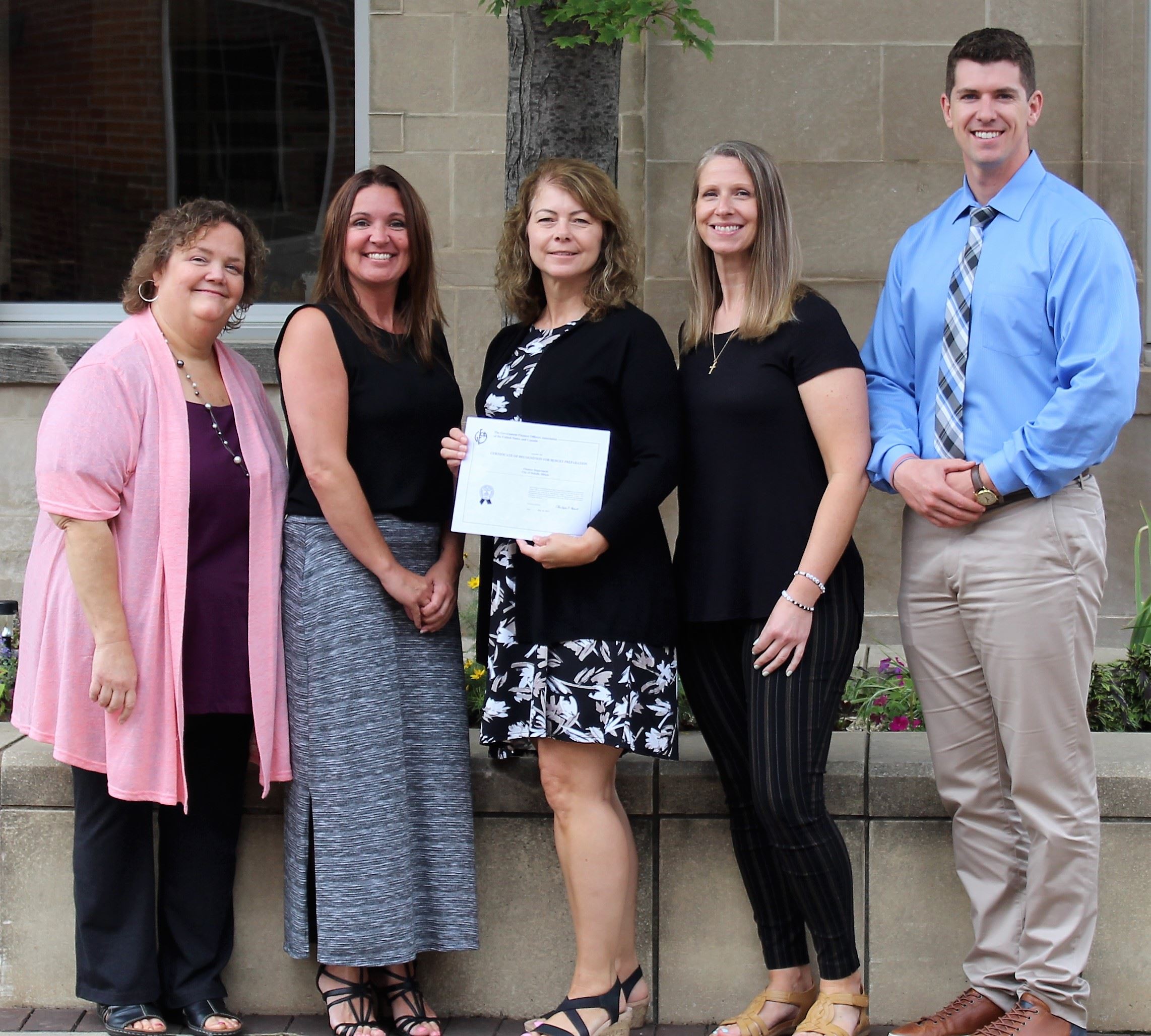 The Finance & Accounting staff show the GFOA budget award certificate.