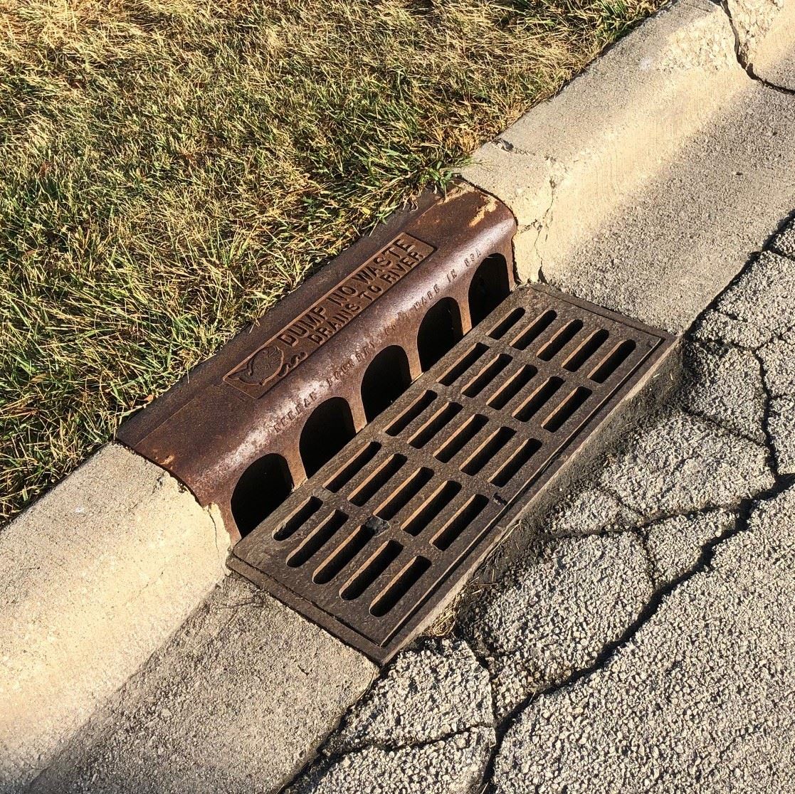 A photo of catch basin along a curb