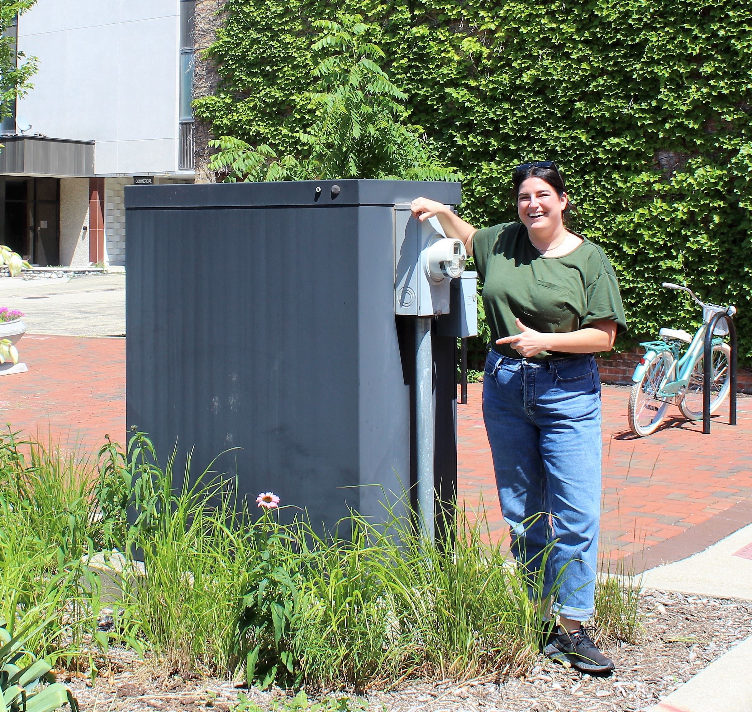 CCEC Member Jeanine Holcomb stands next to a utility box in Van Buer Plaza