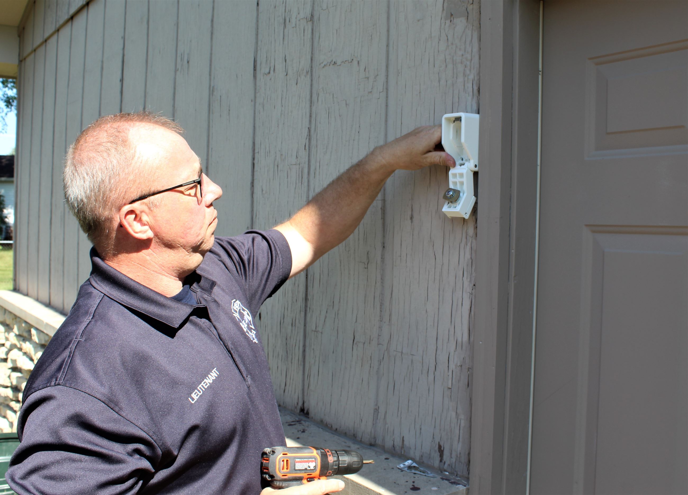 DeKalb Fire Prevention Officer Tom Conley installs a Know Home Box