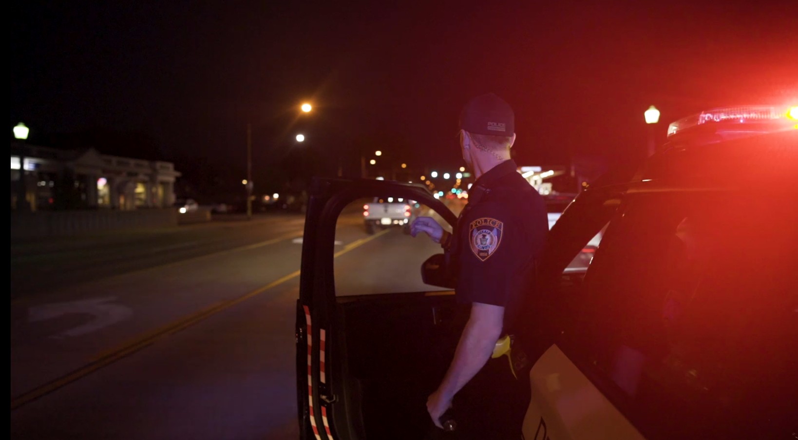 A DeKalb Police officer exits a squad car.