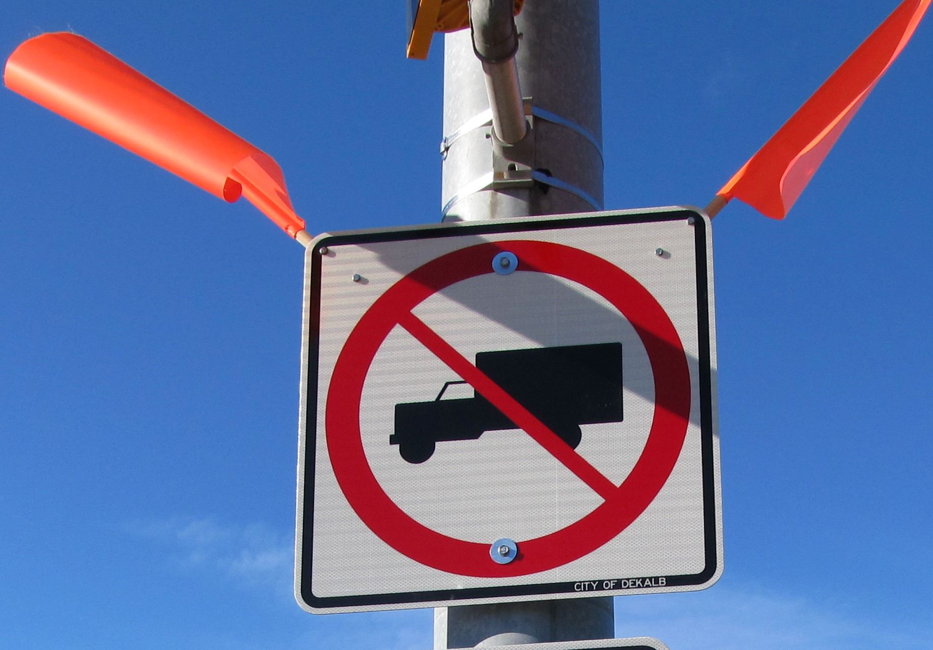 A weight limit sign with orange flags