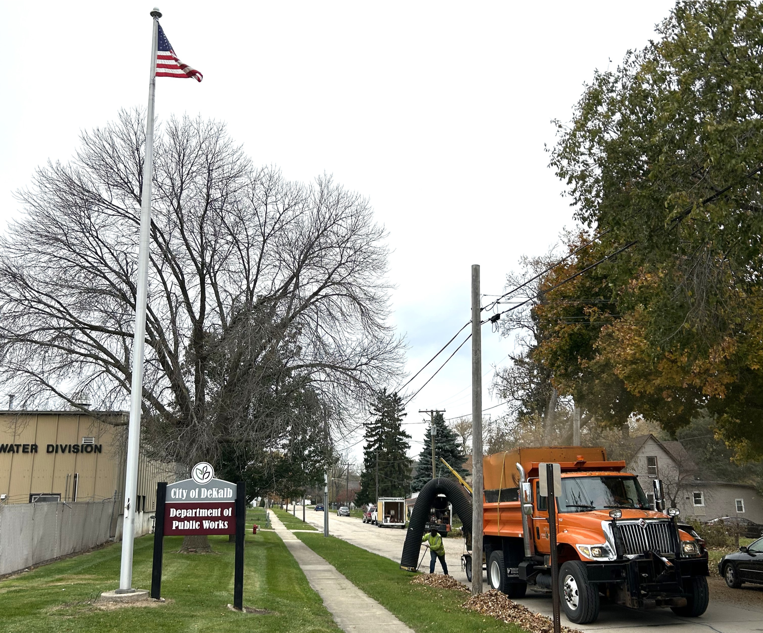 A Public Works employees vacuums up leaves from a parkway.