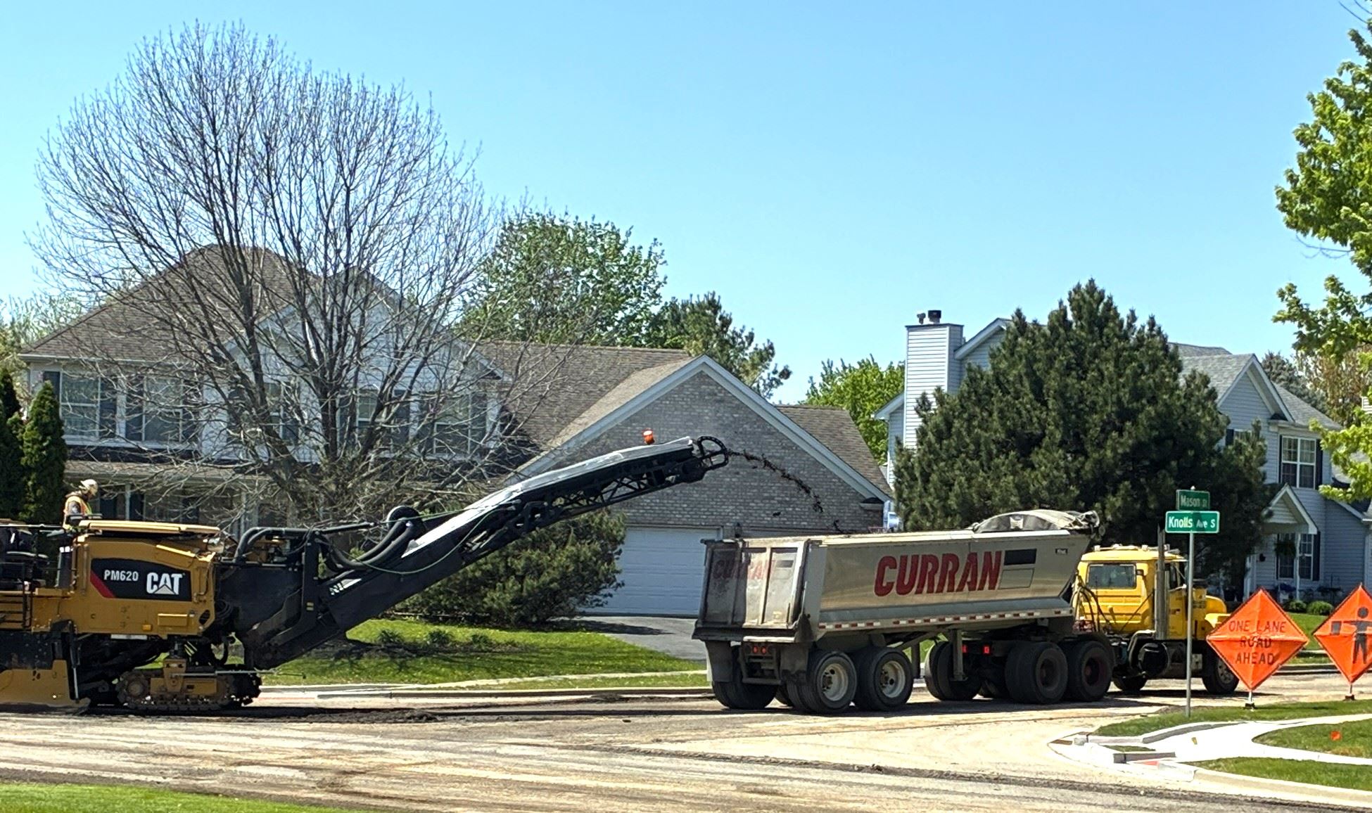 Pavement is milled into the rear of a semi truck