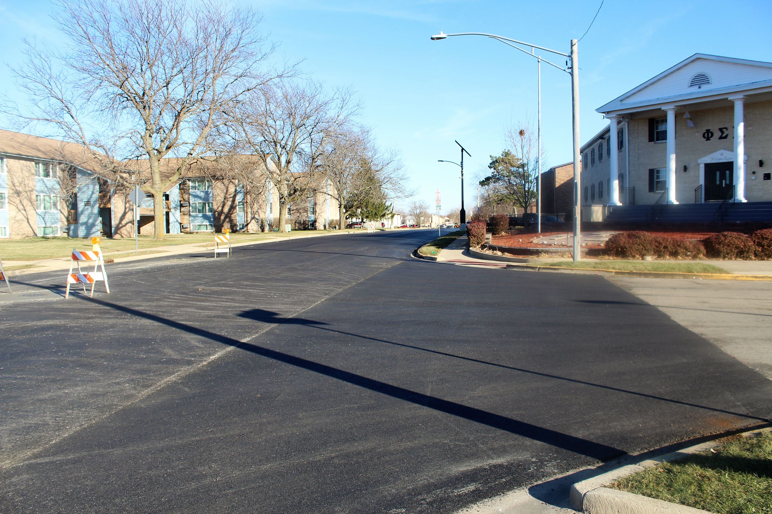 Apartments and a Greek house are shown along a freshly repaved Ridge Rd.